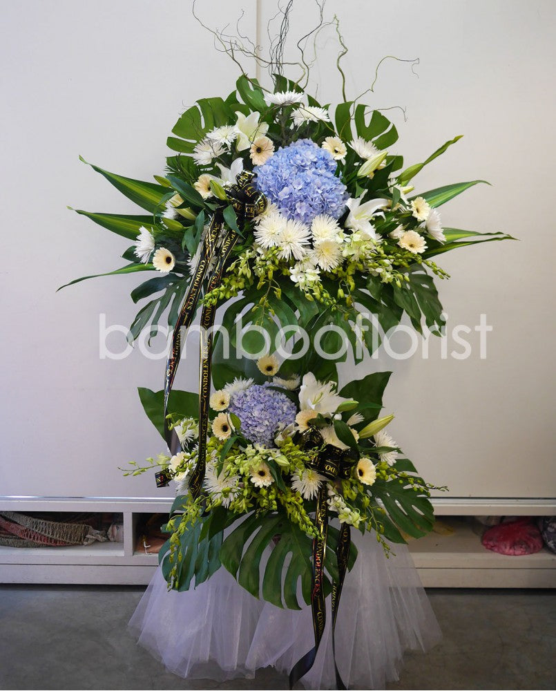 This beautiful, bright white flowers and soothing greens creates a peaceful presentation at any funeral or wake. The classic wreath is delivered on a two tier stand, and is a gracious expression of sympathy and appreciation. For same day condolences flowers delivery in Penang, Butterworth and Bukit Mertajam.
