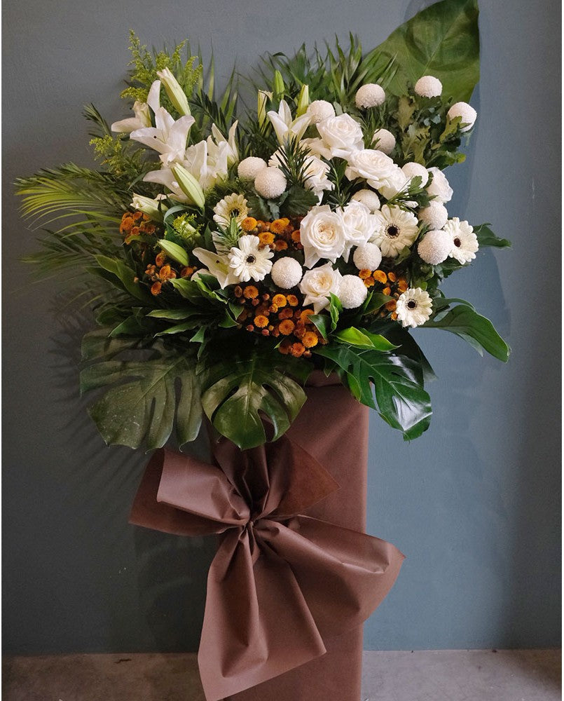 Scented white lilies, white daisies, poms, mums, in a bed of greens. For same day condolences flowers delivery in Butterworth, penang.
