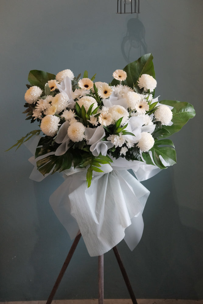 Offer your condolences in a most memorable way and show that you will never forget with this peaceful arrangement. Comprises all in white flowers and greens. For same day condolences flowers delivery in Penang.