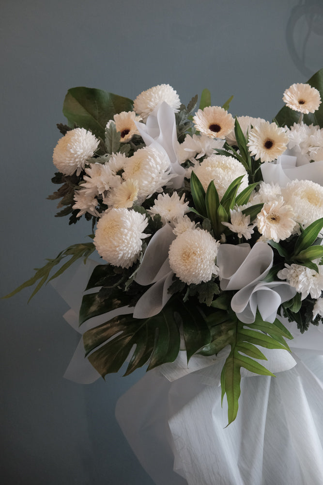 Offer your condolences in a most memorable way and show that you will never forget with this peaceful arrangement. Comprises all in white flowers and greens. For same day condolences flowers delivery in Penang.
