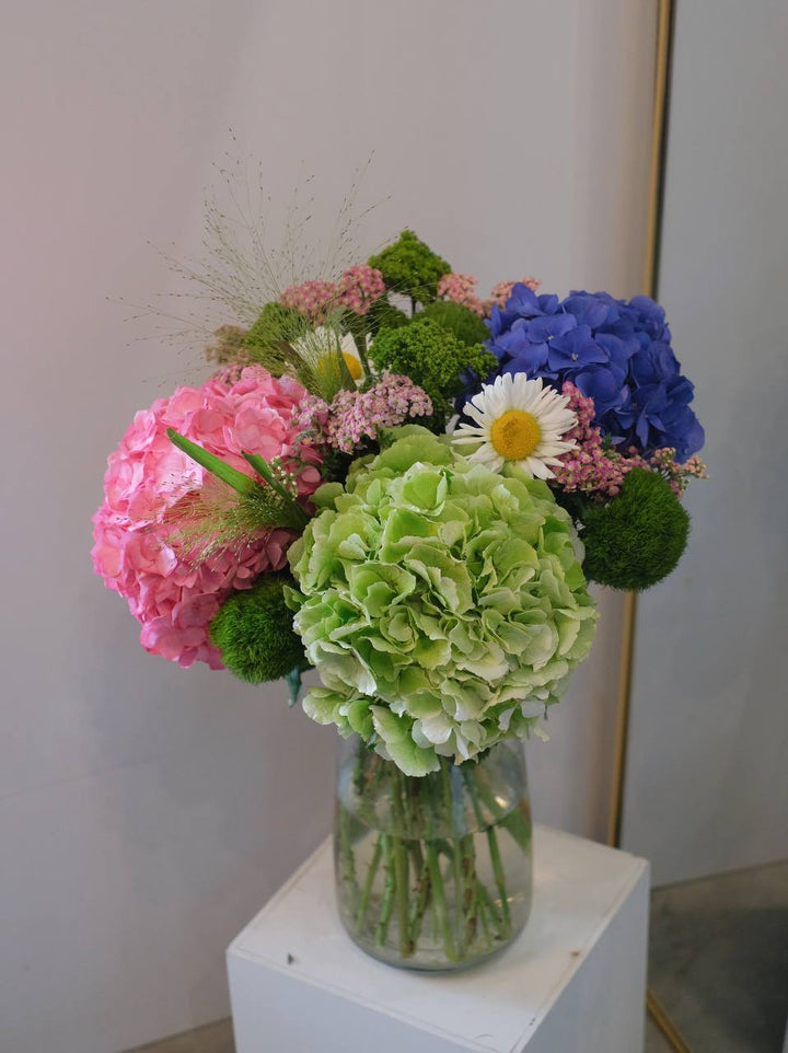 Hydrangeas in a variety of colors, paired with seasonal fillers and leaves, create a beautiful, gender-neutral arrangement. Available for same-day delivery by Penang Florist.