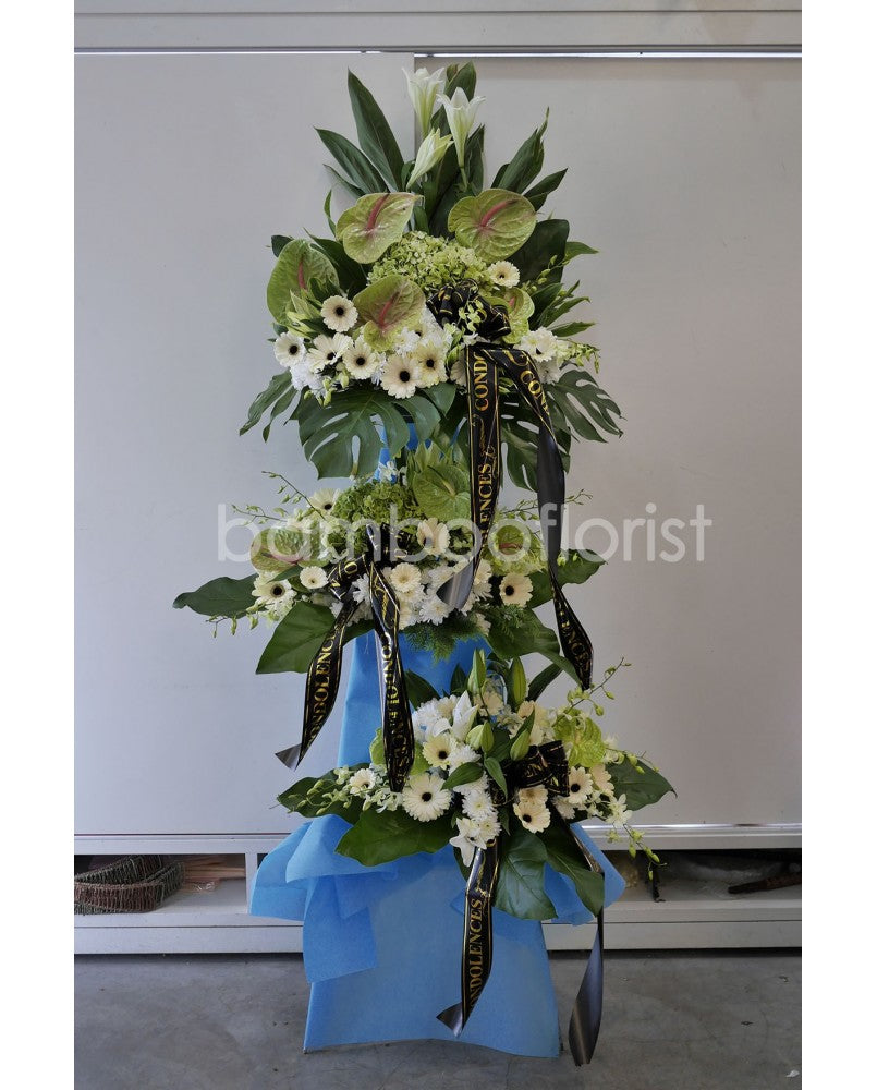 This beautiful, bright white flowers and soothing greens creates a peaceful presentation at any funeral or wake. The classic wreath is delivered on a two tier stand, and is a gracious expression of sympathy and appreciation. For same day condolences flowers delivery in Penang.