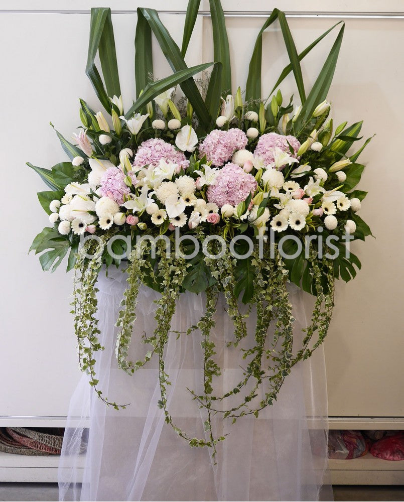 This beautiful, bright white and pink flowers and soothing greens creates a peaceful presentation at any funeral or wake. For same day condolences flowers delivery in Penang.