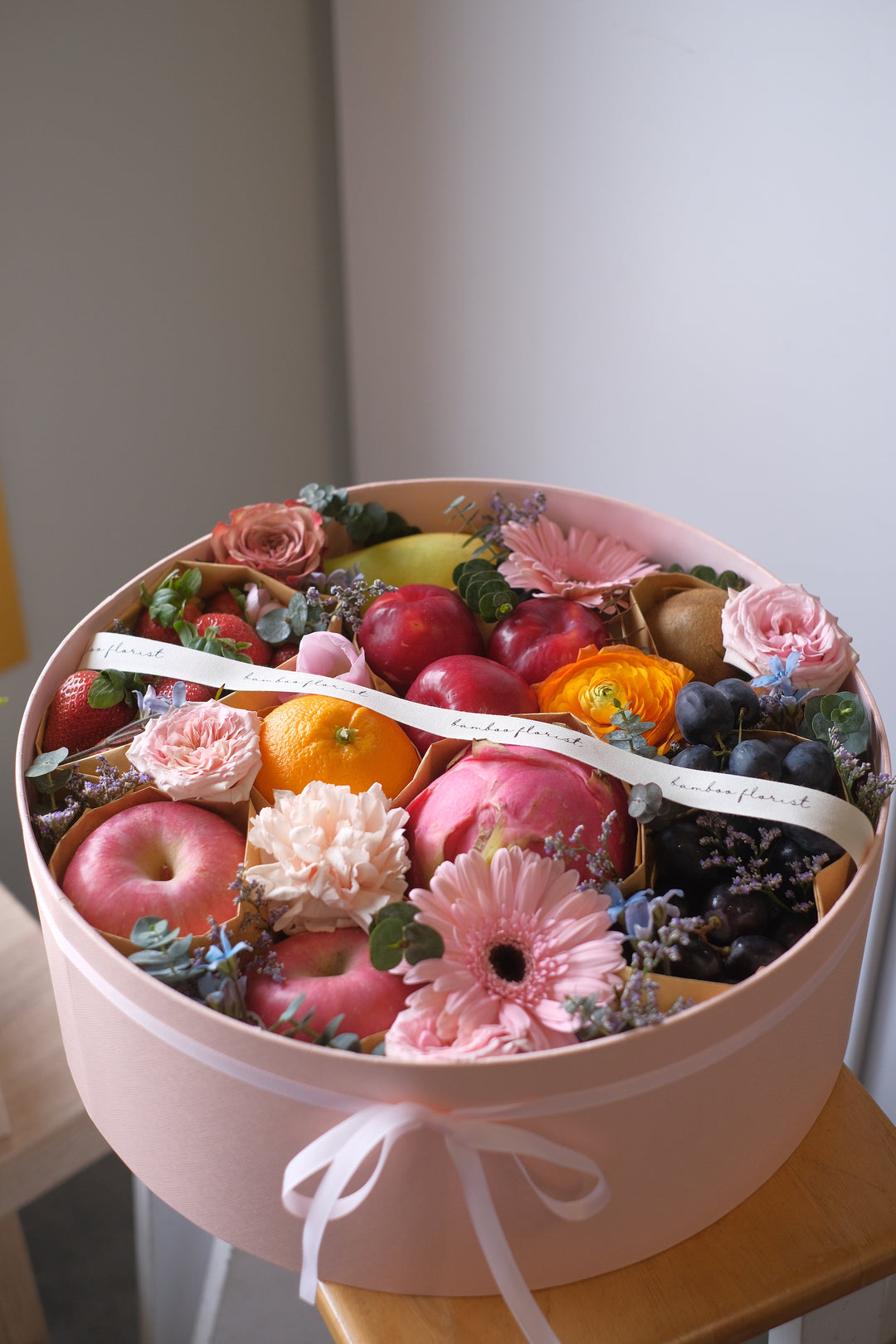 Penang florist, Order online, deliver same day, featuring a tray of fresh exotic & seasonal fruits with 7 varieties, beautifully arranged with flowers.