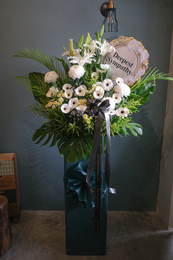 This beautiful, bright white flowers and soothing greens creates a peaceful presentation at any funeral or wake. The classic condolences wreath is delivered on a box stand, and is a gracious expression of sympathy and appreciation.  For same day condolences flowers delivery in Penang.  